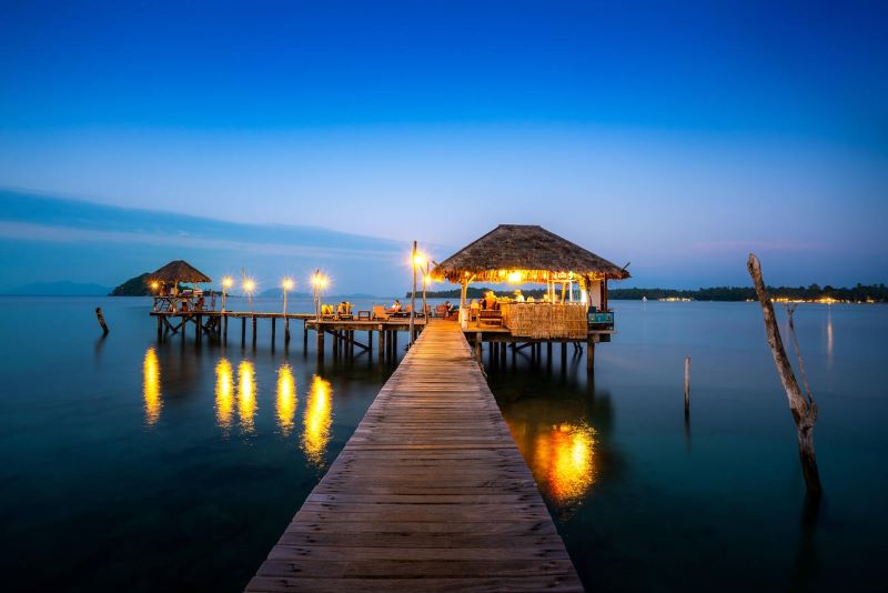 Bar en bois en mer et cabane sous le ciel nocturne à Koh Mak